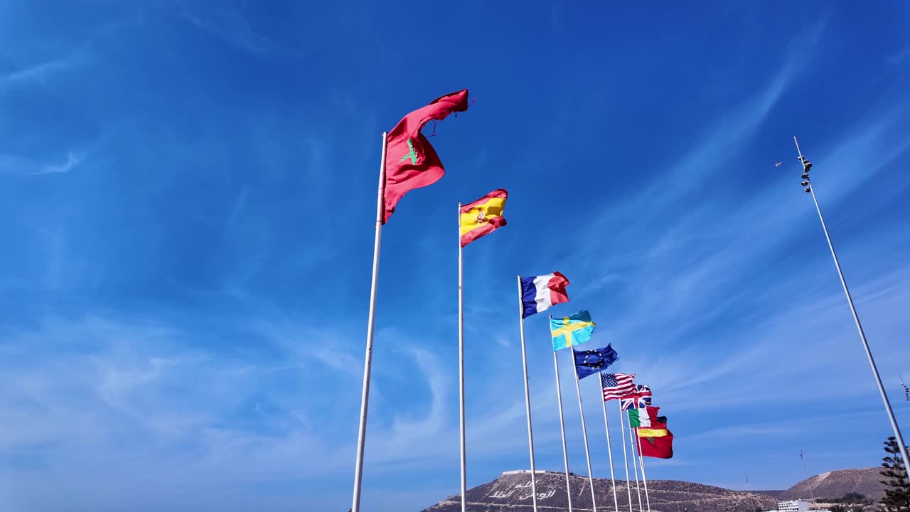 Morocco Spain France Sweden Europe nations flags USA Italy wave Agadir beach, clear blue sky