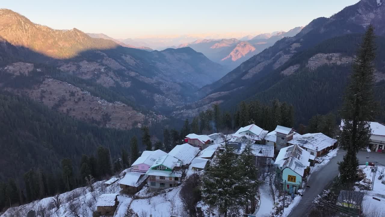 Una vista mozzafiato di un remoto villaggio himalayano incastonato sullo sfondo di immense montagne innevate dopo una recente nevicata. Questa scena tranquilla è perfetta per film di viaggio o sulla natura.