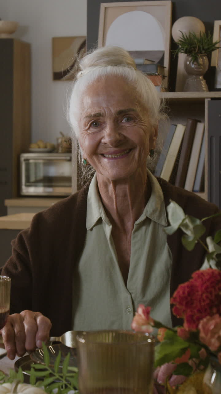 Portrait of a Smiling Elderly Woman at a Dinner Table