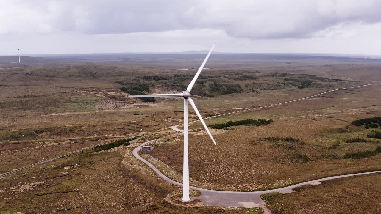 Drone shot on the Hebrides of a wind turbine's blades spinning in the wind