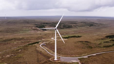 Drone shot on the Hebrides of a wind turbine&#039;s blades spinning in the wind