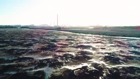 dried gross black bubbled tar of asphalt lake in willemstad curacao, attempt to clean up with excavator