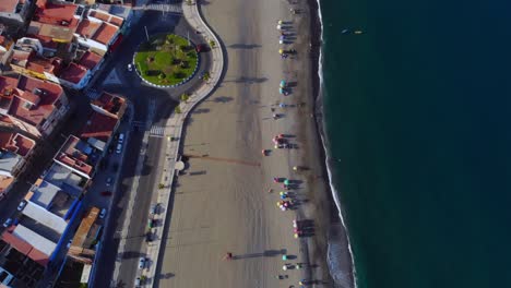 imágenes de aviones no tripulados filmando en una playa cerca de una carretera y una rotonda