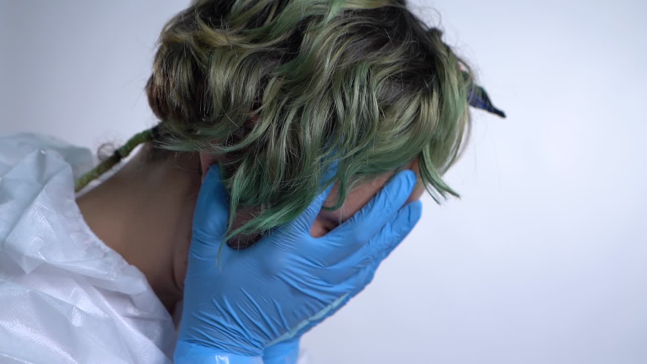 간호사는 코로나 바이러스 상황에 필사적으로 손을 얼굴에 대고 철회합니다.