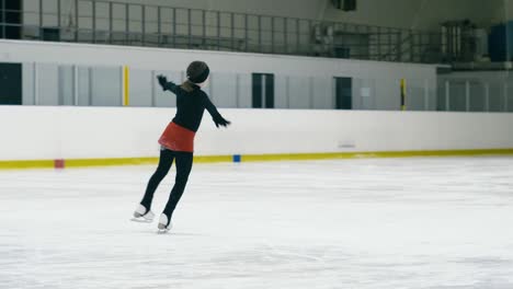 small figure skater making toe loop inside ice arena