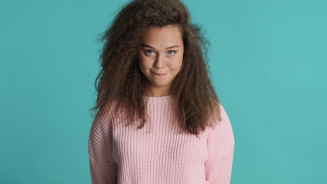 Caucasian-curly-haired-woman-nodding-in-front-of-the-camera.