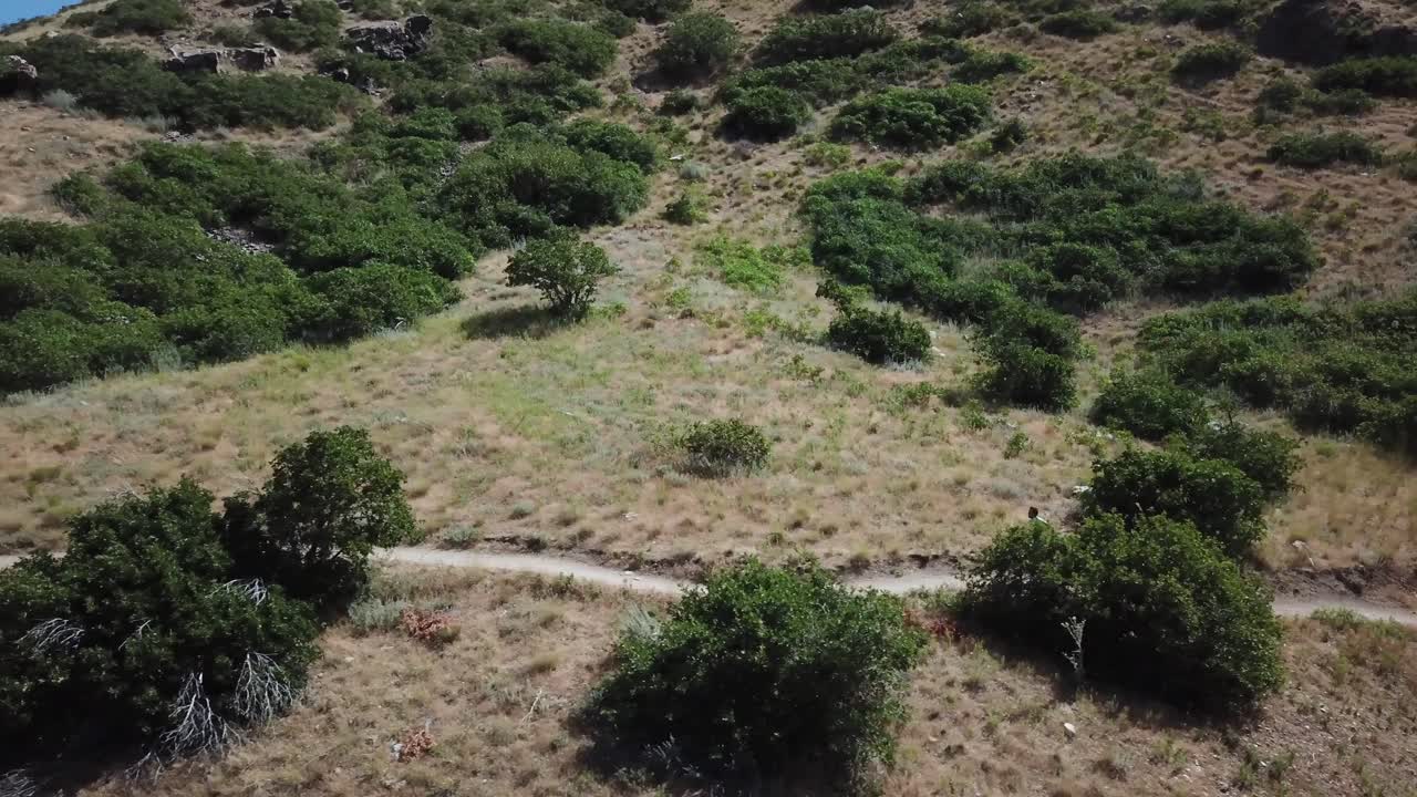 disparo de un dron siguiendo a un hombre activo corriendo por los senderos de montaña al aire libre de wasatch sobre draper city, utah