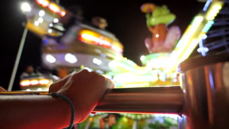 point of view watching an amusement park carnival ride lit up at night