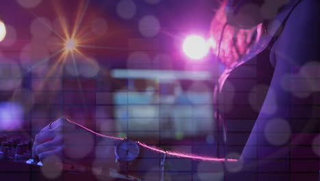 composición de la sección media de la mujer caucásica dj tocando en la discoteca con el deporte de la luz en el fondo