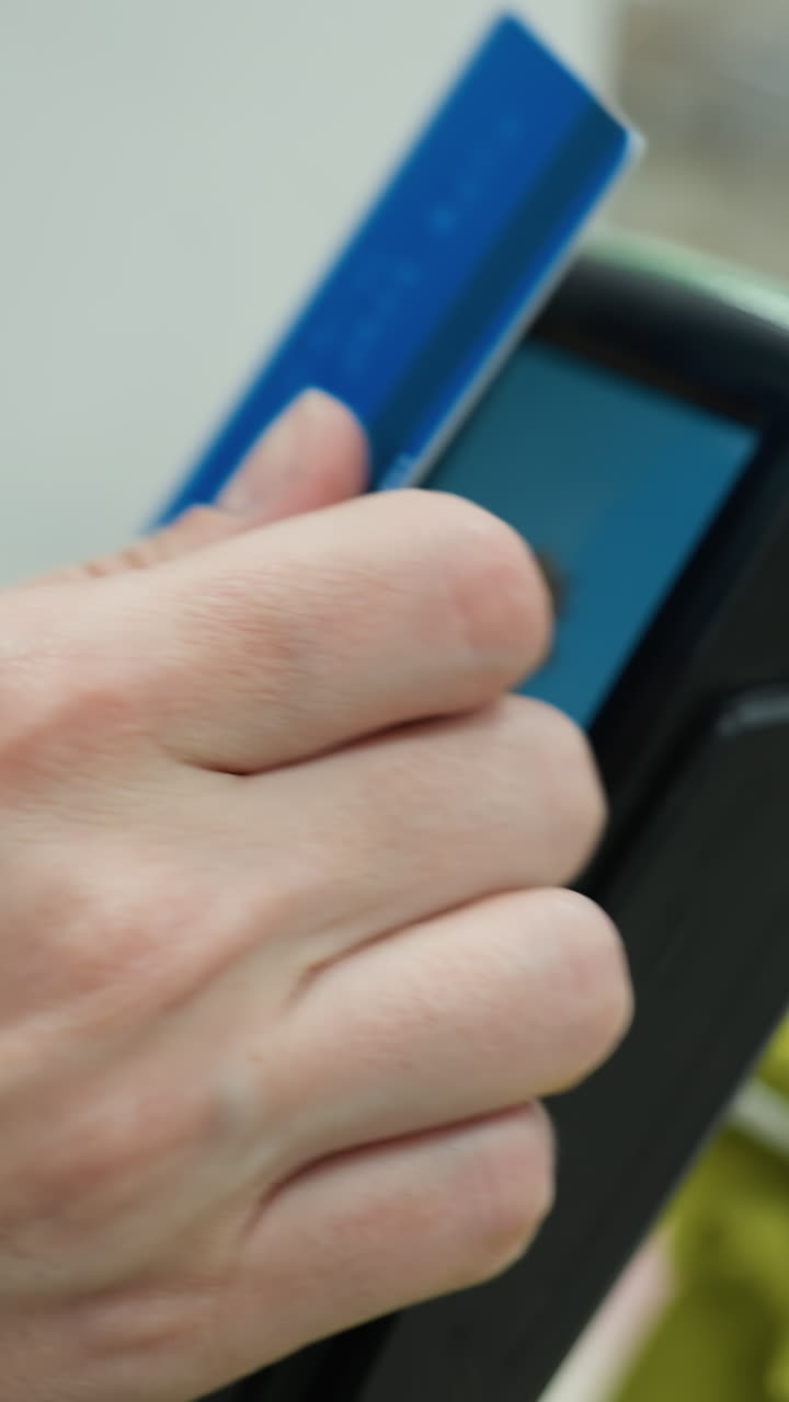 vista cercana de una persona que hace un pago con una tarjeta. el video se graba desde una perspectiva en primera persona con una cámara de mano, mostrando una mano insertando una tarjeta de crédito en una terminal de pago