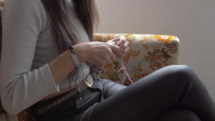 Medium view of woman working with hands to crochet and knit a piece