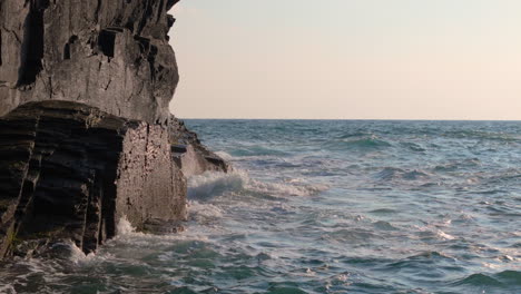 waves crashing on dark rocky coast
