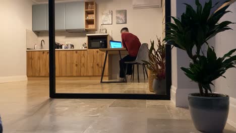 lapso de tiempo con una persona masculina nómada digital que trabaja usando una computadora portátil en la cocina