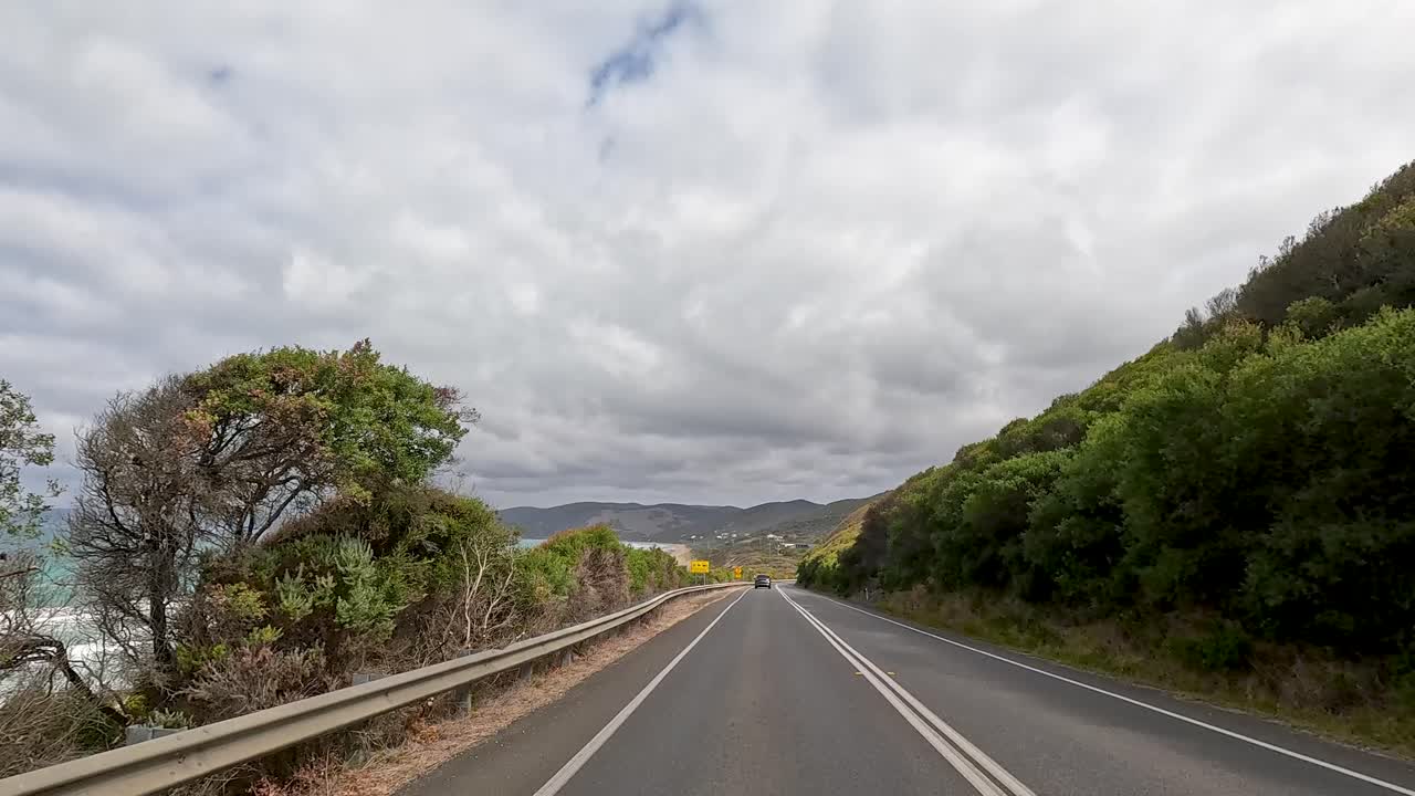A 30-second video captures a drive along the Great Ocean Road, showcasing coastal views, lush greenery, and winding roads under cloudy skies