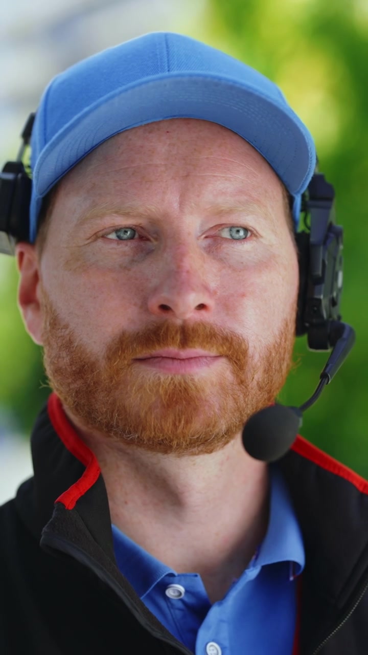 Man Wearing Headset and Cap Communicating Outdoors