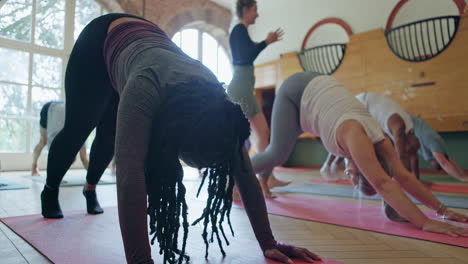 group yoga class practicing downward dog pose