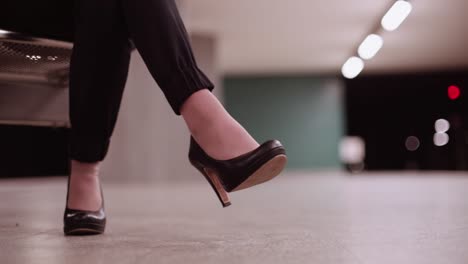 business woman in subway station tapping her foot waiting for train