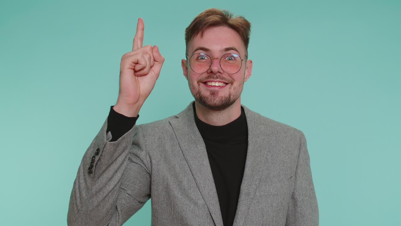 Inspired business man pointing finger up showing eureka gesture solution idea inspiration answer