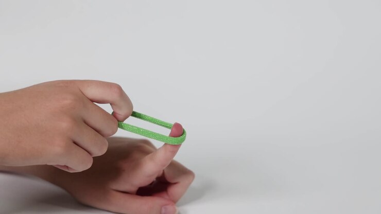 Hand flinging a green hair tie