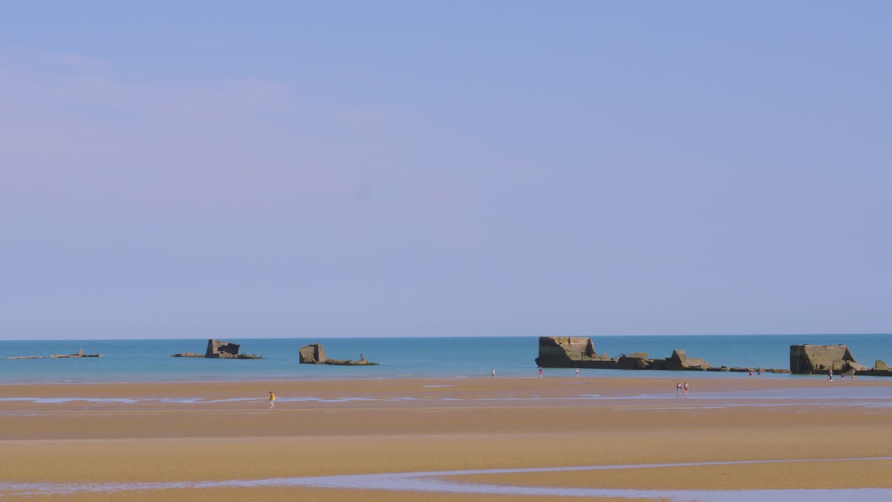 Pan Across Historic Gold Beach D-Day WW2 Landing Bay with Artifical Harbour Ruins in Sea in Normandy, France, Europe 4K