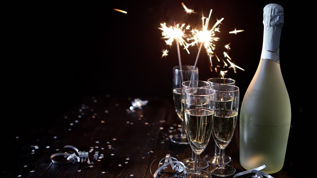 Immagine di composizione da festa: bicchieri pieni di champagne posizionati su un tavolo nero.
