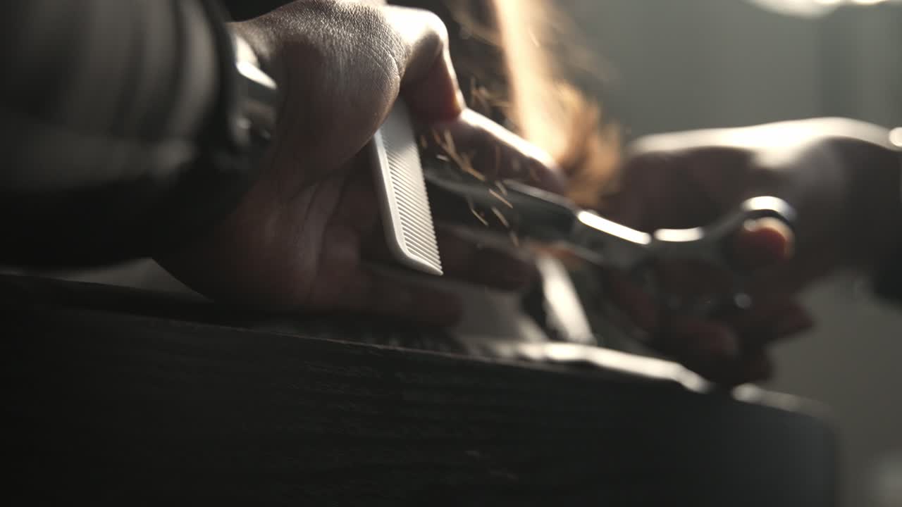 Slow motion cinematica a 240 fotogrammi di un parrucchiere che taglia capelli scuri con le forbici