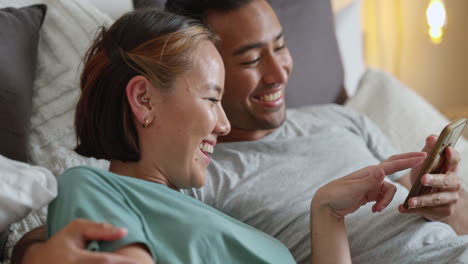 Asian-couple,-phone-or-laughing-while-bonding