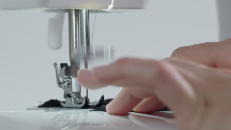 coser una tela negra con una máquina de coser