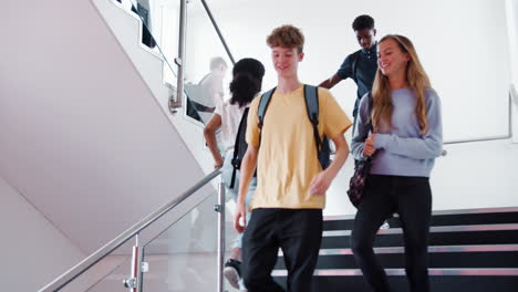 high school students and staff walking on stairs between lessons in busy college building