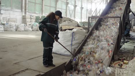 una joven afroamericana revisa una cinta transportadora en una planta de reciclaje. control de la contaminación