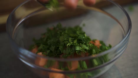 primer plano de un chef condimentando salmón con hierbas