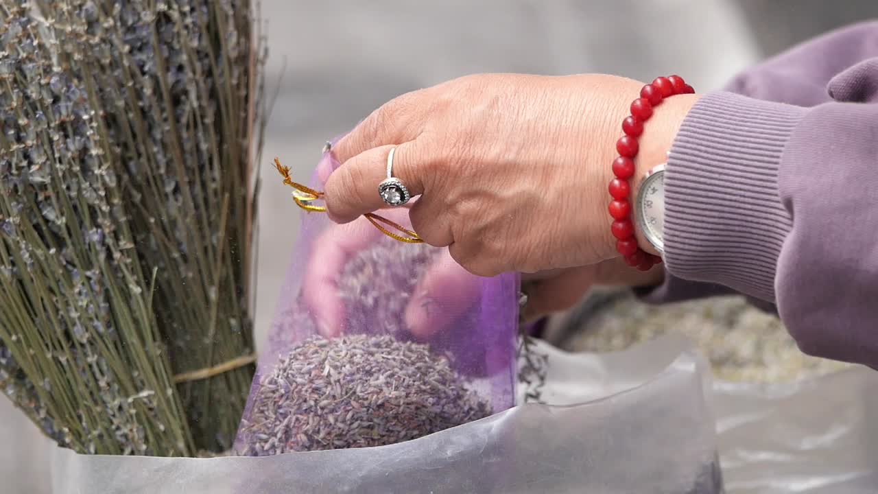 Hands filling a bag with lavender