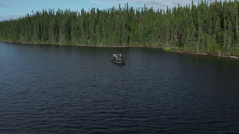 drone flying around a fishing boat and moving away showing a large creek on a beautiful and wild lake