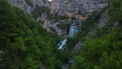 Aerial-View-Of-Valley,-Waterfalls-And-Pine-Tree-Forest-In-Winter