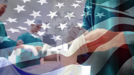 animation of flag of usa waving over surgeons in operating theatre