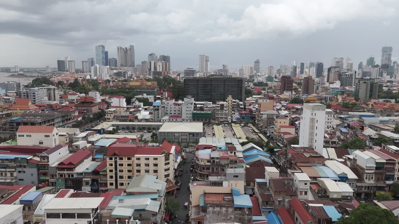 Aerial footage in Phnom Penh city center, Cambodia. Camera is moving foward the Hyatt Hotel flying above old roofs 1-2