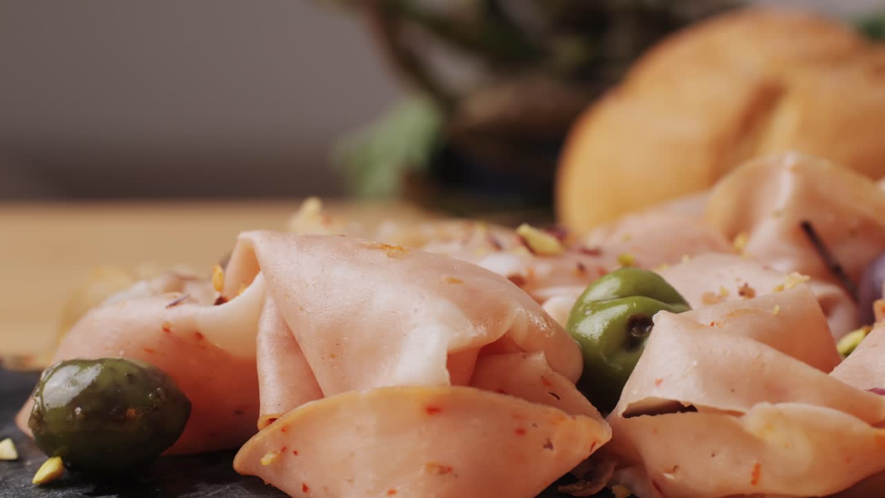 Ham italian mordatella, man Slices Of Traditional Italian antipasti mortadella sausage on a wooden cutting board, close up macro of chicken or turkey jamon, fat breakfast dish.