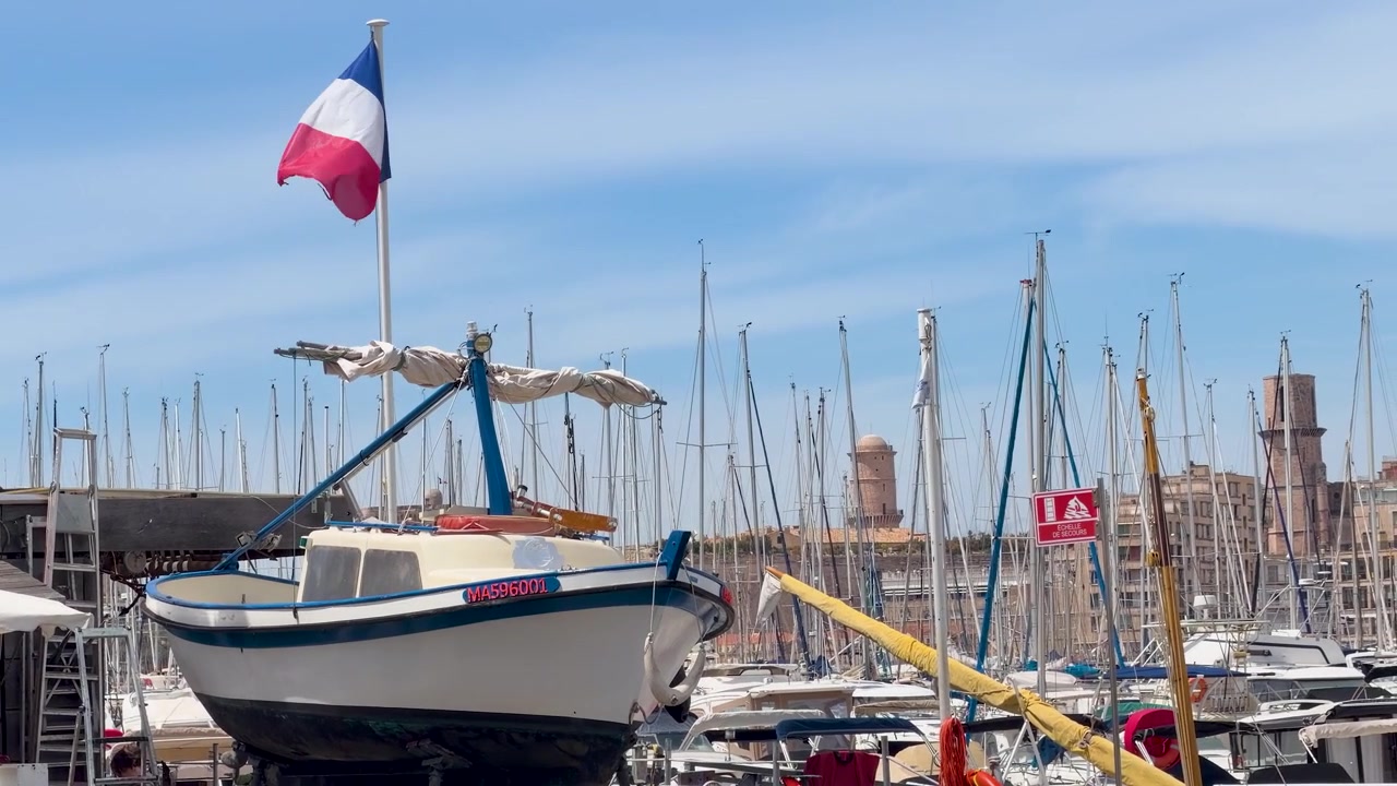 Et fransk flag vajer på toppen af en fiskebåd, der ligger fortøjet i den historiske Vieux Port havn.