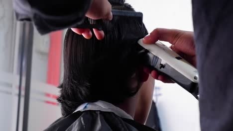 barber works with hair clipper