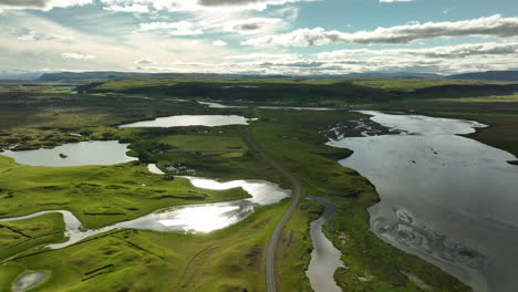 ponds and river along a road in iceland aerial shot