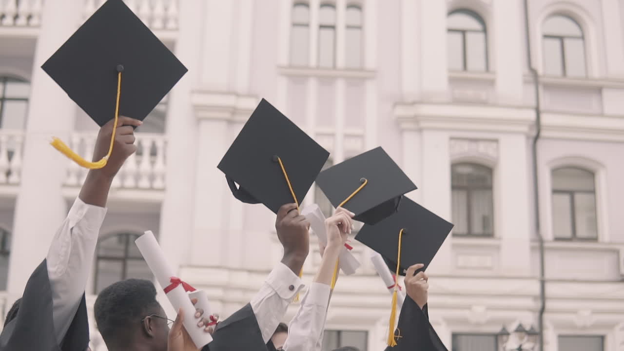Multicultural Group Of Graduate Students Flapping Their Caps On Air
