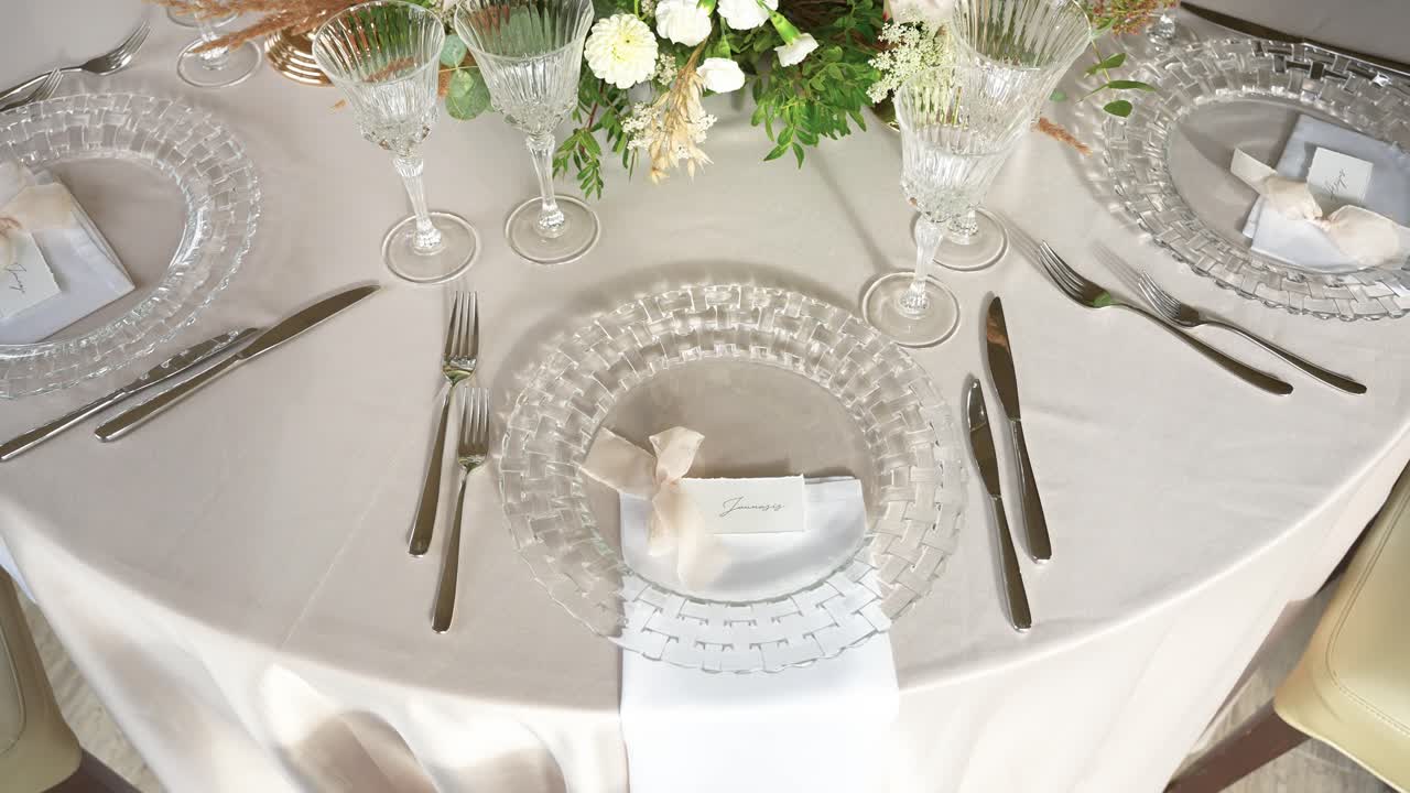 A beautifully arranged wedding table setting featuring exquisite crystal glassware and delicate floral centerpiece. Perfect for formal occasions and elegant events