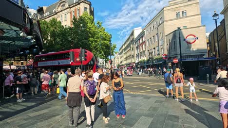 crowds gather near a london bus and station