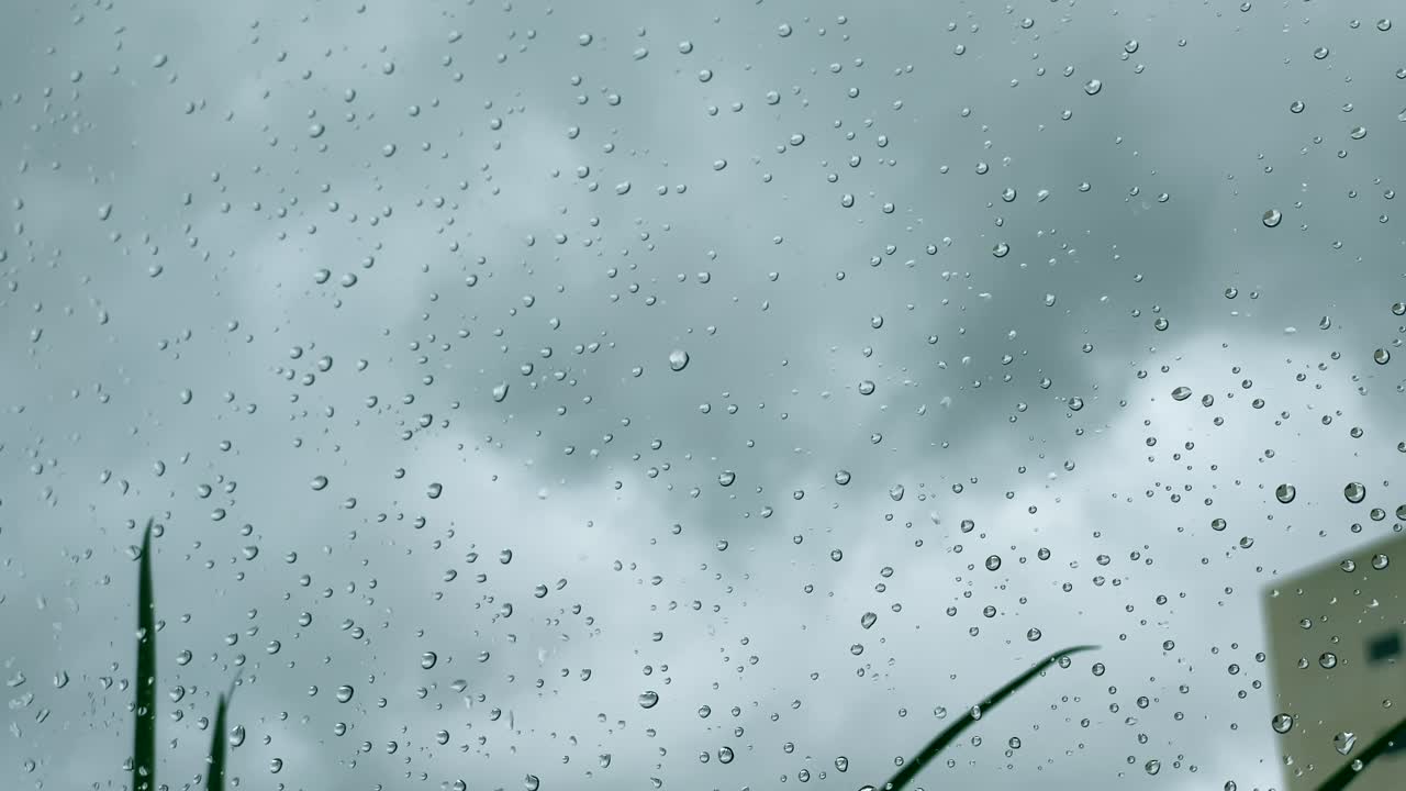 Raindrops on a window during a cloudy rainy day