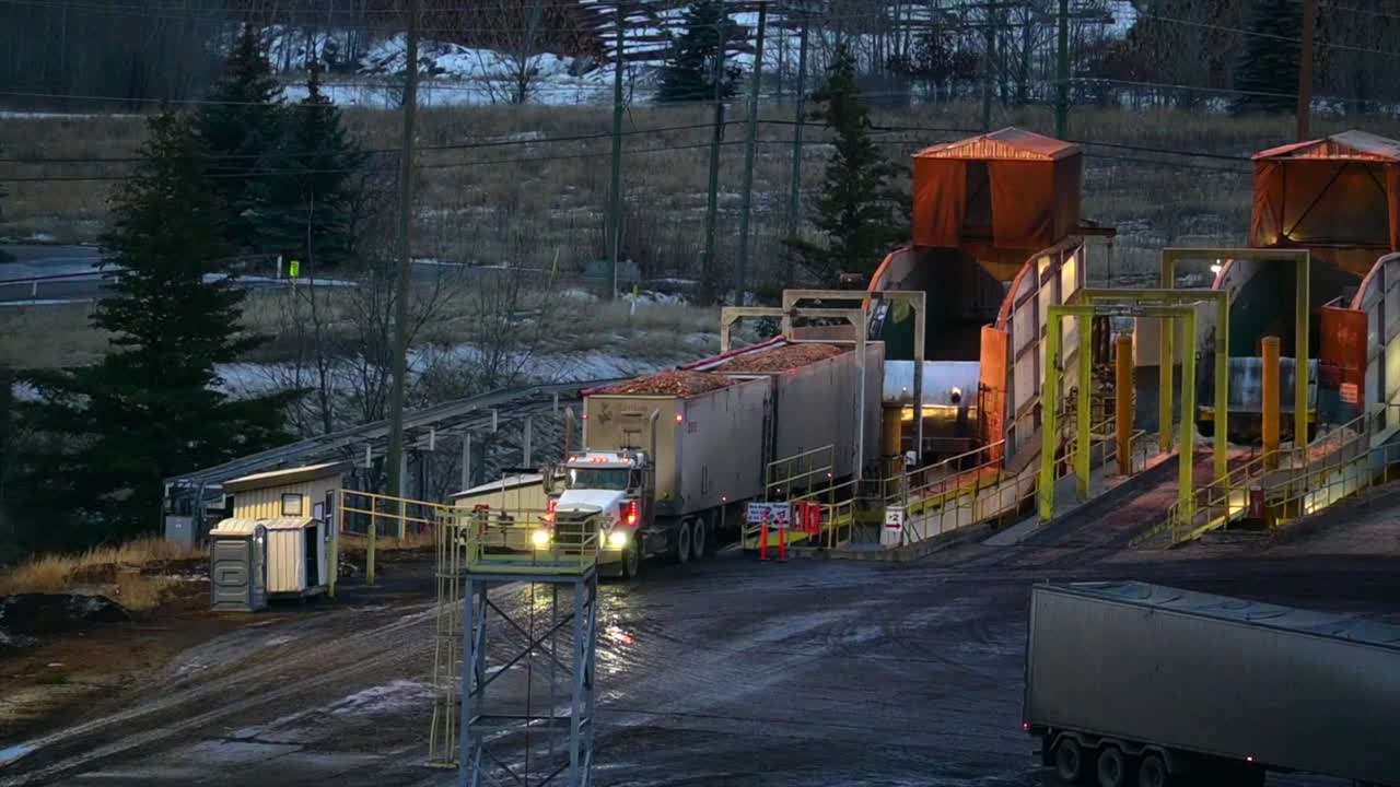 поставки на лесопильный завод: увеличенный вид с воздуха на полуприцеп, разгружающий лесопродукцию на лесопильном заводе