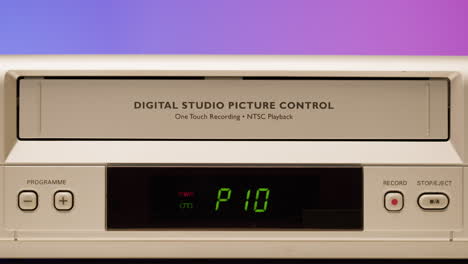 vintage vcr with hand operating the eject mechanism