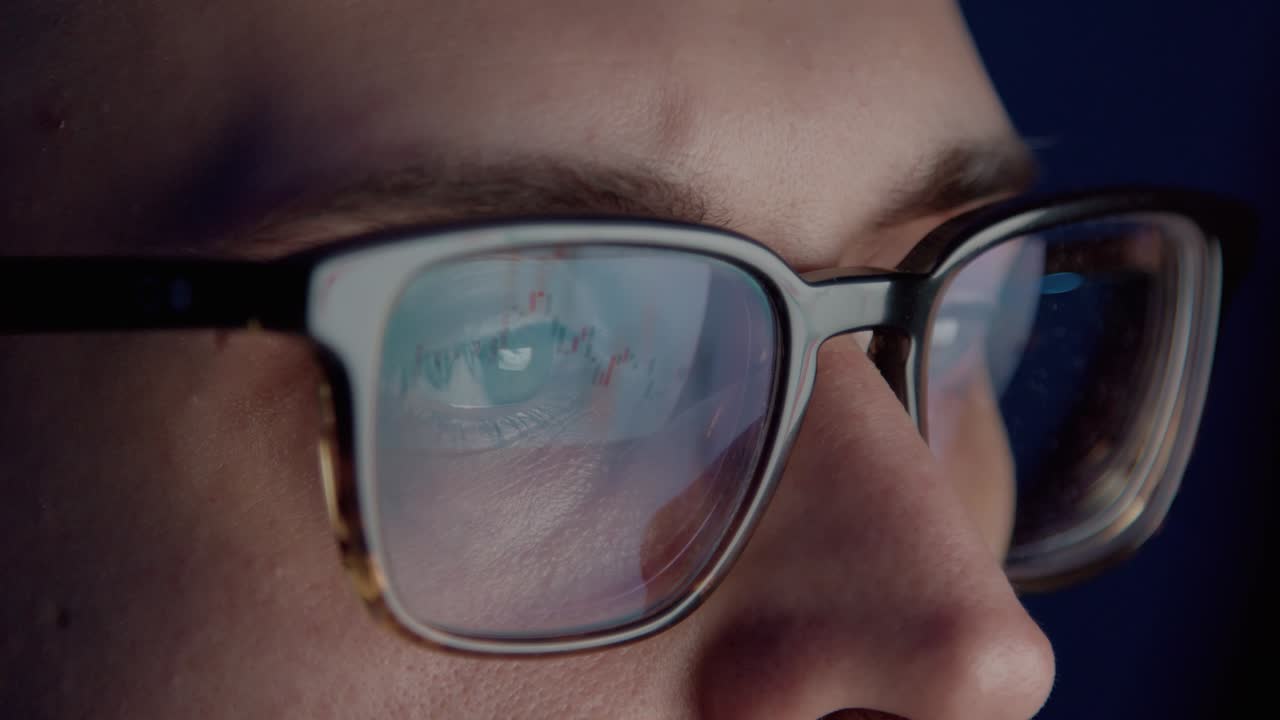 hombre comerciante con gafas mirando la pantalla de la computadora por la noche