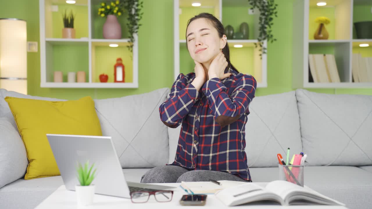 피곤한 아시아 여성이 목을 잡고 있습니다.