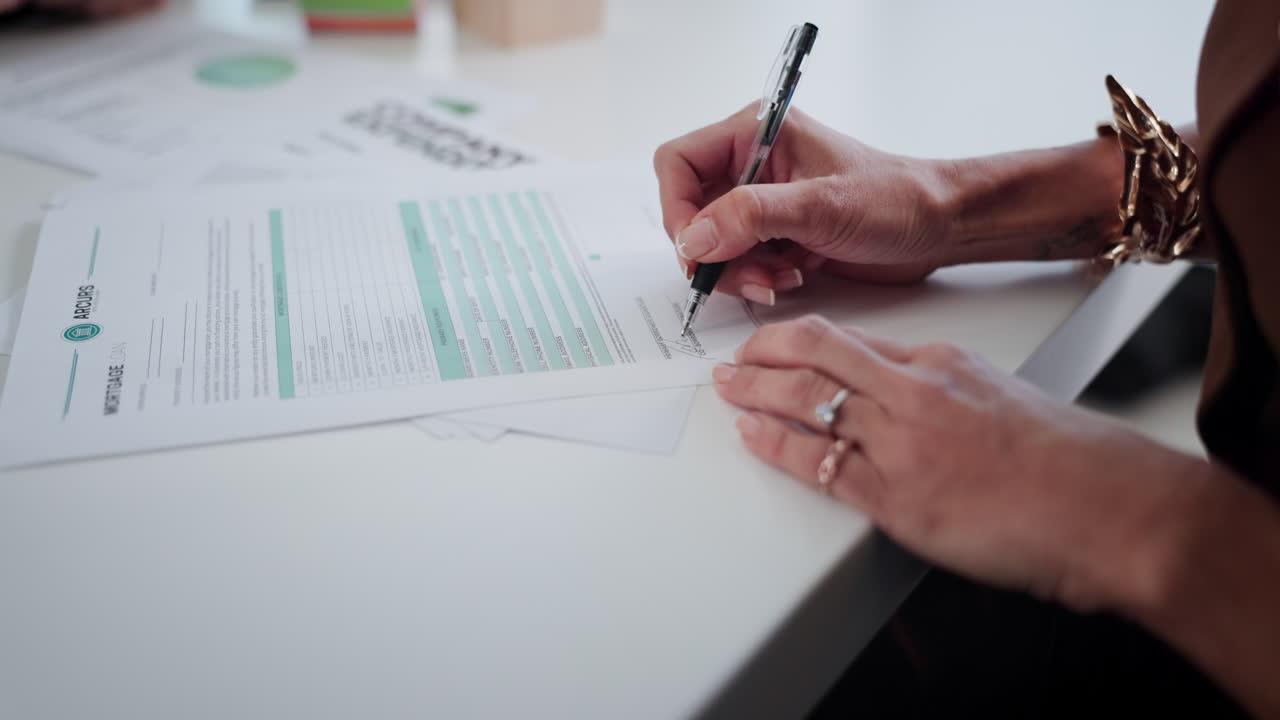 Close-Up of Hands Signing Mortgage Loan Document with Pen