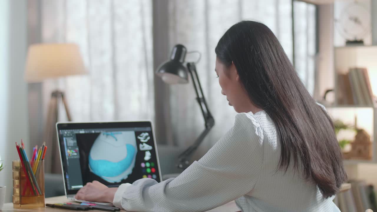 Woman designing shoes on a laptop